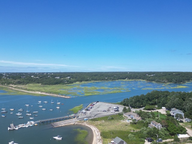 Aerial view of Pamet Harbor with boats moored along the channel and salt marsh extending east