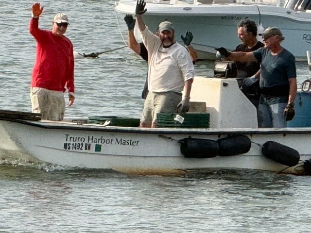 Volunteers waving from the Truro Harbor Master's boat during the August 2026 clam relay